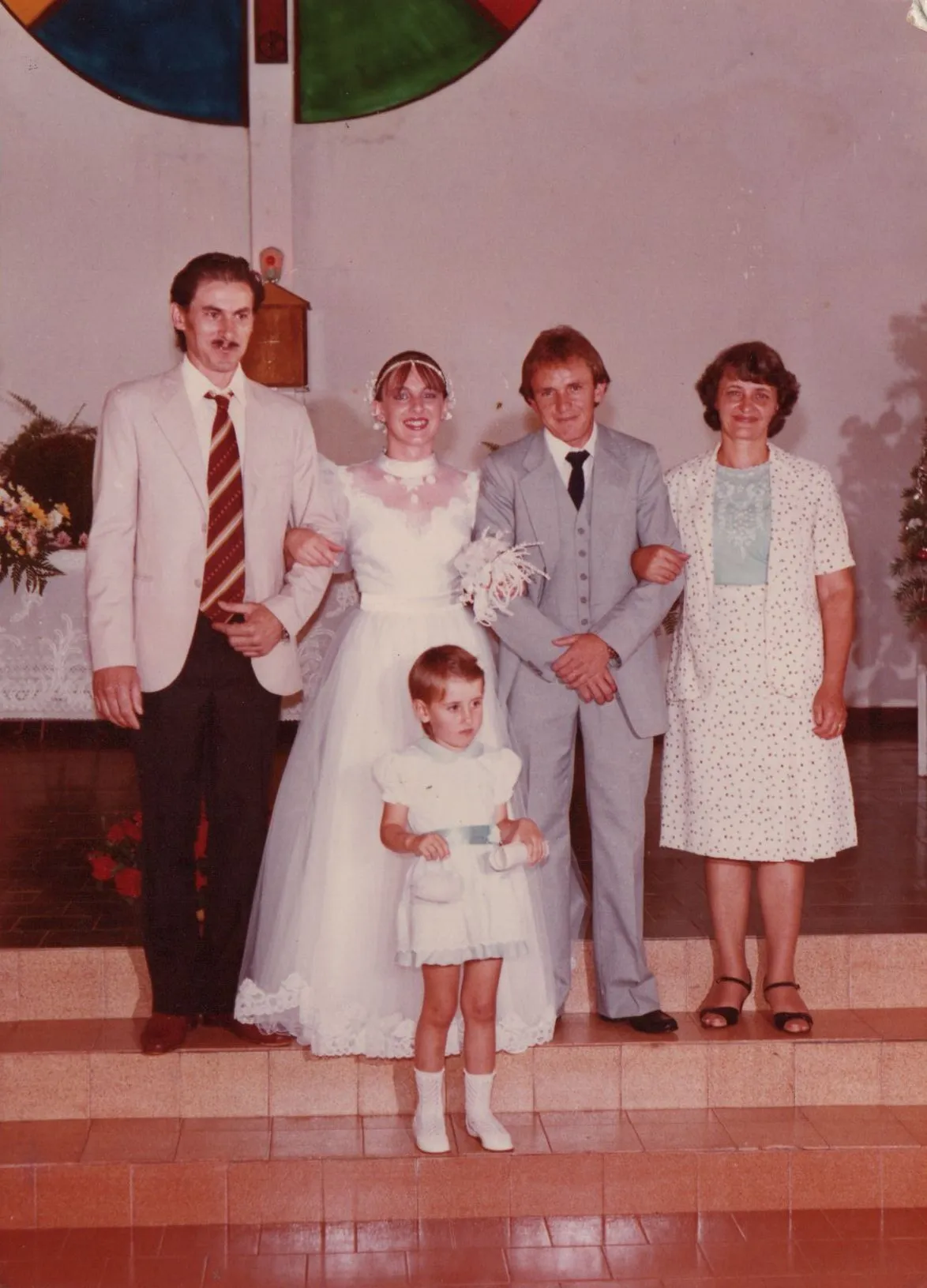 Uma noiva e um noivo, um padrinho e uma dama de honra em um altar da igreja para fotos de casamento. (Original)