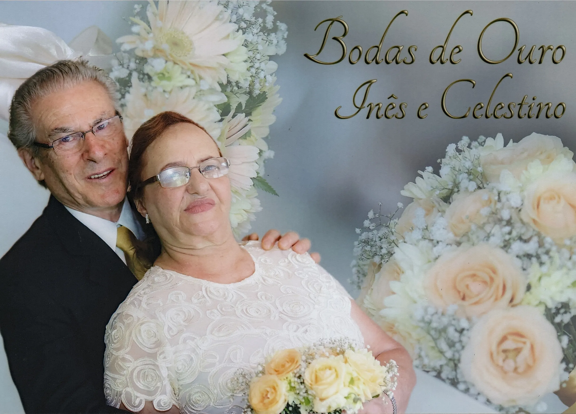 Um casal mais velho está sorrindo para a câmera em uma celebração de casamento, com o homem vestindo um terno e a mulher um vestido branco de renda, segurando um buquê de flores.