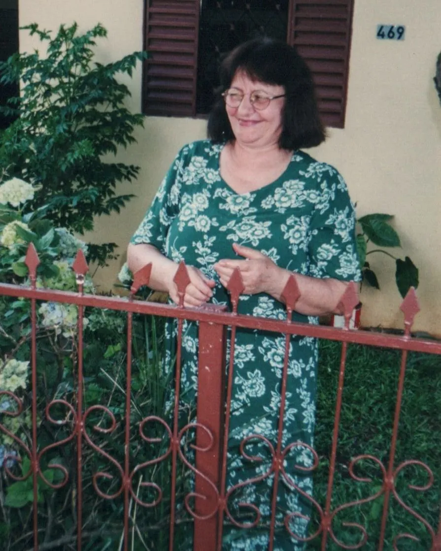 Dona Ignez rindo no jardin frente de casa