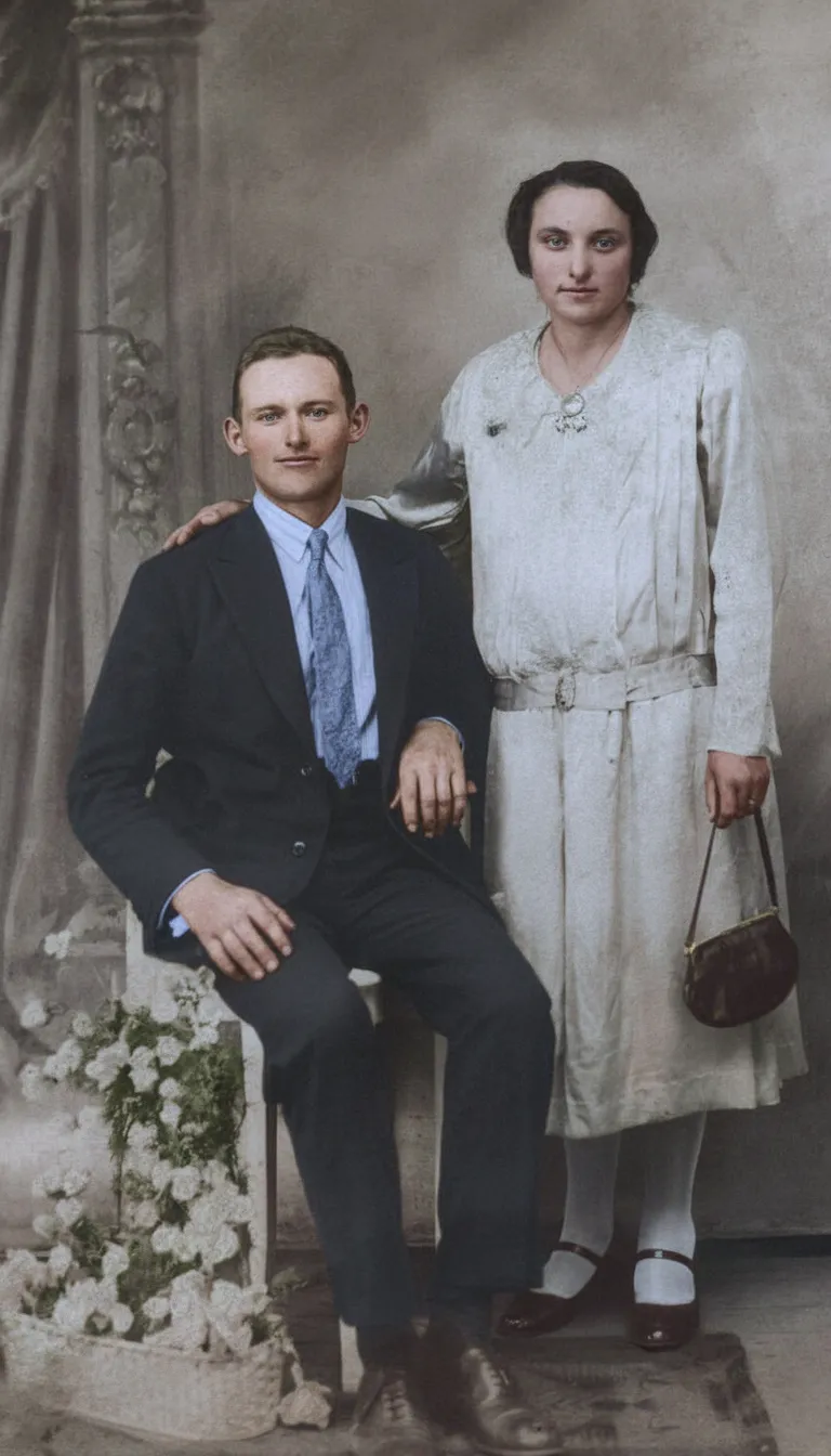 Casal posando para um retrato; a mulher está em pé e o homem está sentado.