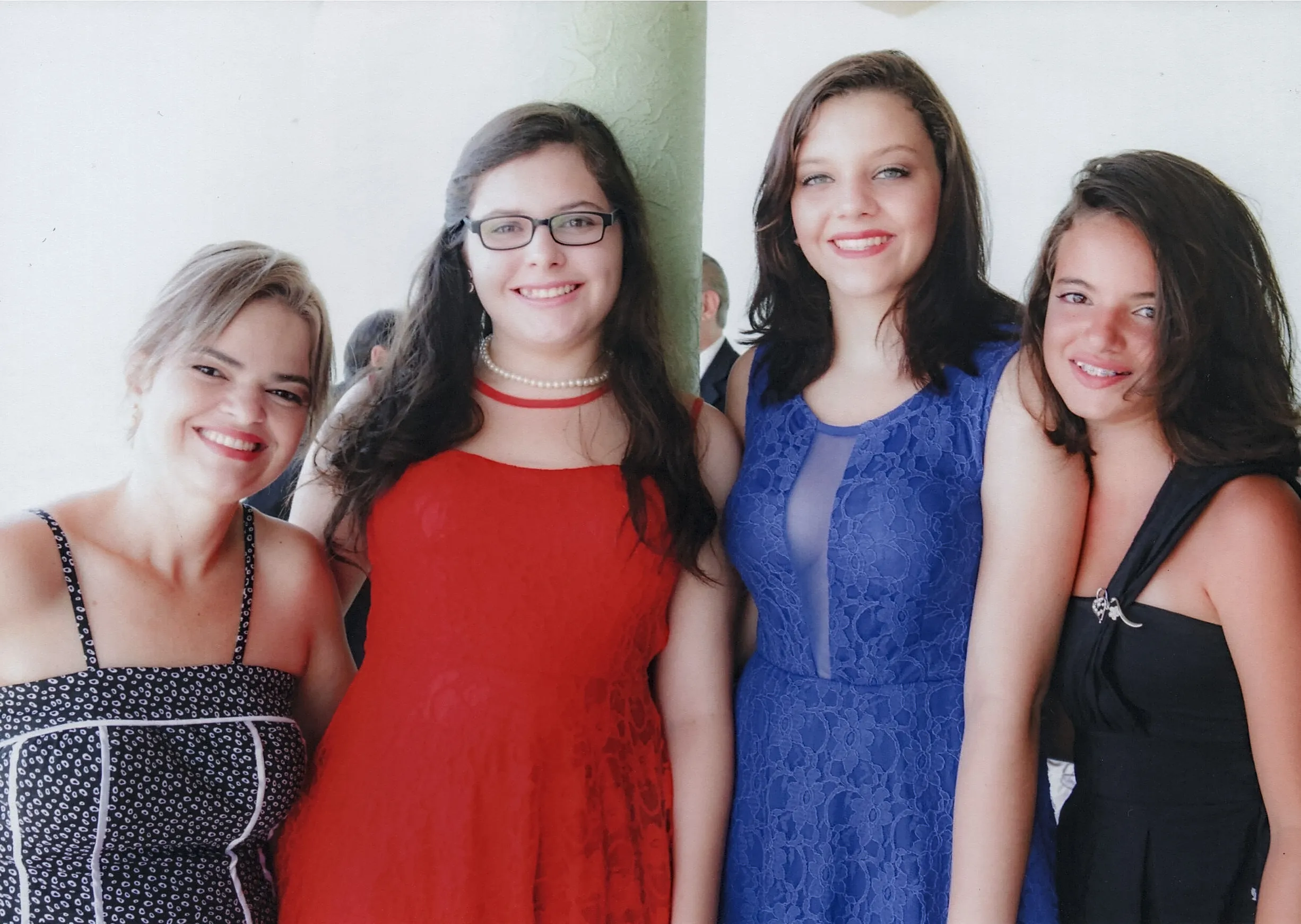 Quatro mulheres jovens em vestidos formais se destacam em um plano de fundo leve.